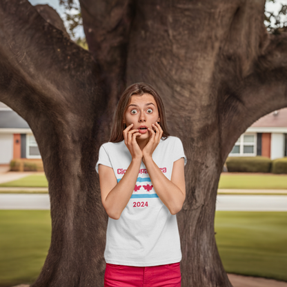 Young woman wears a white t-shirt with "Cicadapalooza" printed on it and the Chicago flag with the red stars replaced by cute, red cicadas. She's standing in front of a huge, old tree with a look of shock on her face. Her hands are at her cheeks.